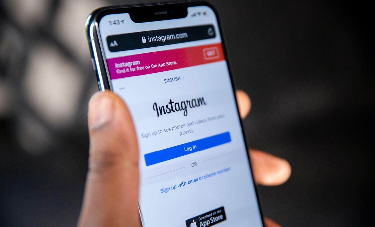 Mão segurando um iPhone com o Instagram aberto
